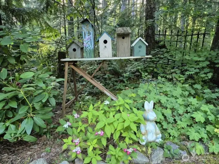 Charming birdhouses nestled within the lush garden and greenbelt, adding a touch of whimsy to the serene natural surroundings.