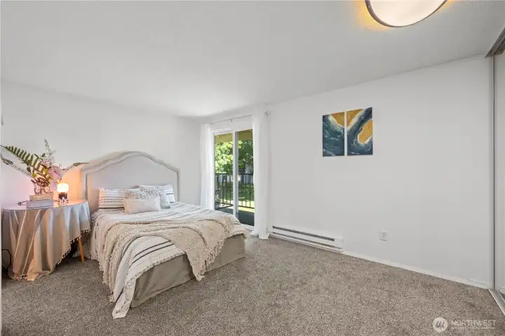 Comfortable primary bedroom featuring large windows, neutral tones, and views facing the quiet interior courtyard