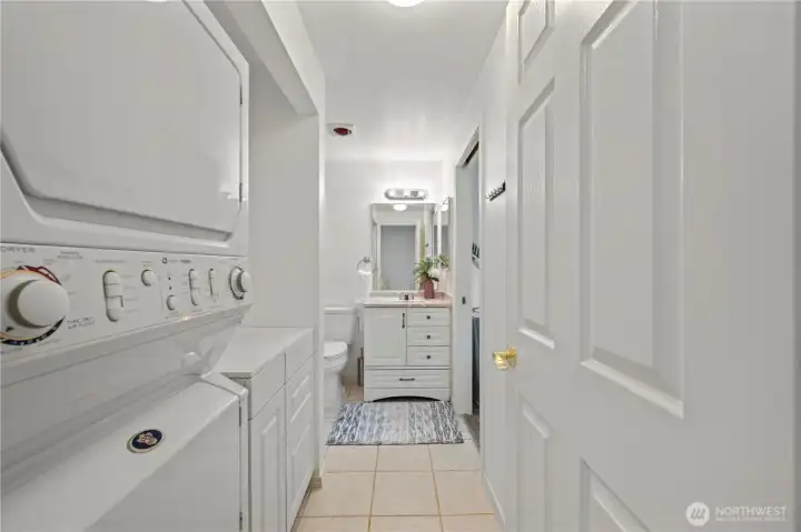 Full main bathroom featuring a spacious vanity, tub-and-shower combo, and dedicated laundry space.