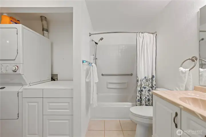 Main bathroom laundry area equipped with a stacked washer and dryer unit for maximum space efficiency