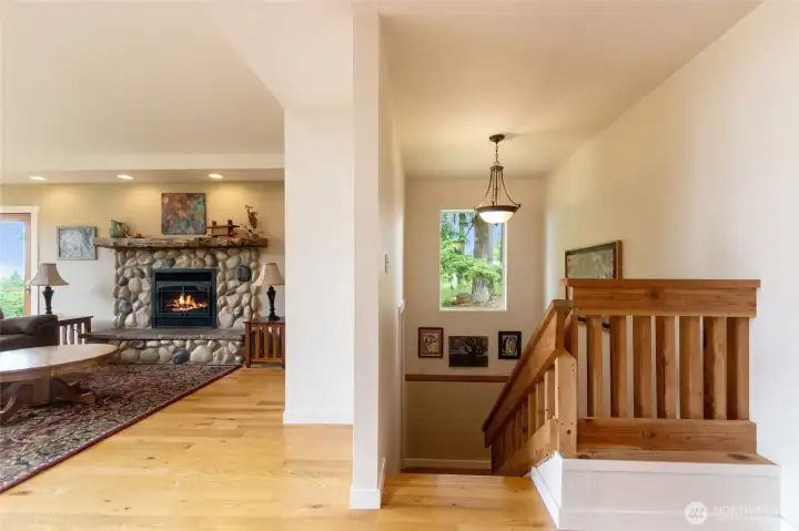 Beautiful fir doors, and upgraded recessed lighting showcase the timeless quality and craftsmanship found throughout the home. A striking cultured river rock fireplace with a gas insert serves as the focal point, creating a warm and inviting atmosphere for gathering with family and friends. Thoughtfully designed custom cabinetry provides a discreet space for entertainment equipment while maintaining the room's clean, attractive appearance. These carefully selected finishes and details combine beauty, function, and character—features that are increasingly rare to find in today's homes.Featuring stunning hardwood floors, beautiful fir doors throughout the home, and upgraded recessed lighting, this living space showcases timeless quality and craftsmanship—details that are increasingly rare to find in today’s homes.
