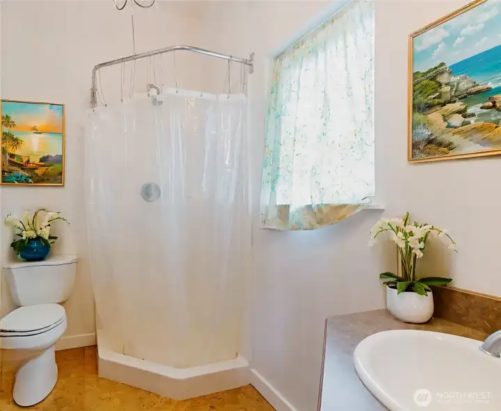 This photo has been digitally staged to showcase the potential of the space. The attached ¾ bath features a corner shower, generous storage, and a thoughtful layout designed for both comfort and convenience.