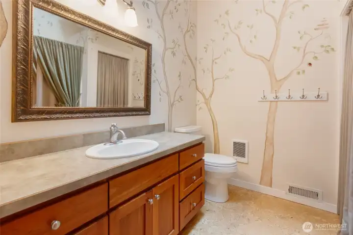 Conveniently located on the main level, this full bath offers added flexibility with plumbing already accessible behind the adjacent closet, making it well-suited for the future installation of a stackable washer and dryer. Thoughtfully designed to serve guests and everyday living needs, it provides both functionality and potential for future customization.
