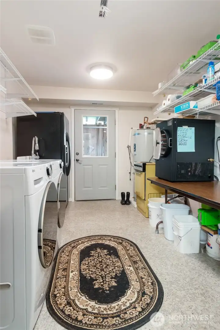 Generously sized and highly functional, this laundry room is wired for an electric range, providing the opportunity to create a future kitchenette if desired. Whether supporting extended living arrangements or enhancing the flexibility of the lower level, this space offers valuable potential. Current range is not included and will not remain with the property.