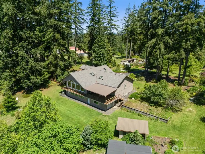 This aerial view showcases the backyard, established orchard, and surrounding landscape.