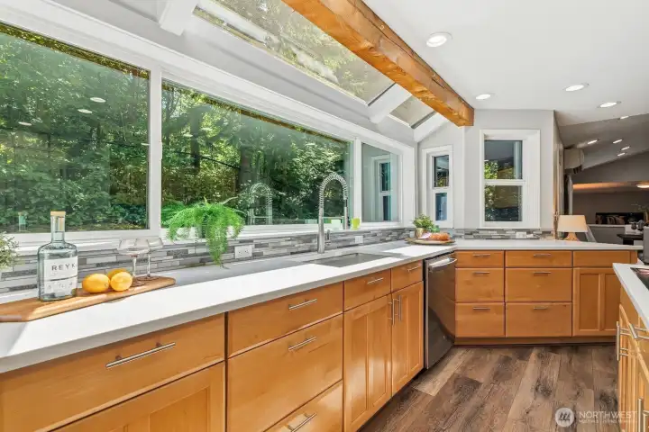 Gorgeous mosaic tile backsplash, undermount sink, and wraparound countertops overlook the serene backyard. Gorgeous mosaic tile backsplash, undermount sink, and wraparound countertops overlook the serene backyard.