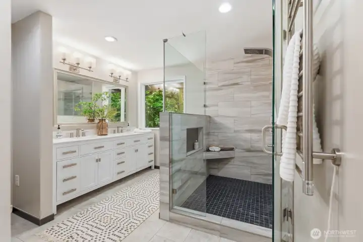 Luxurious primary bath features quartz countertops, double sink vanity, updated mirror, lighting and hardware, heated towel rack, linen storage, and tons of natural light. Luxurious primary bath features quartz countertops, double sink vanity, updated mirror, lighting and hardware, heated towel rack, linen storage, and tons of natural light.
