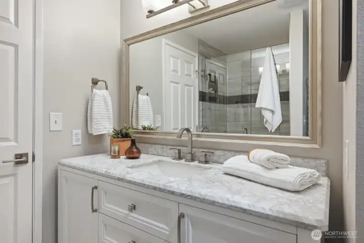 Remodeled ensuite bath features quartz countertop, updated vanity, stylish lighting, a beautifully tiled walk-in shower and heated towel warmer. Remodeled ensuite bath features quartz countertop, updated vanity, stylish lighting, a beautifully tiled walk-in shower and heated towel warmer.