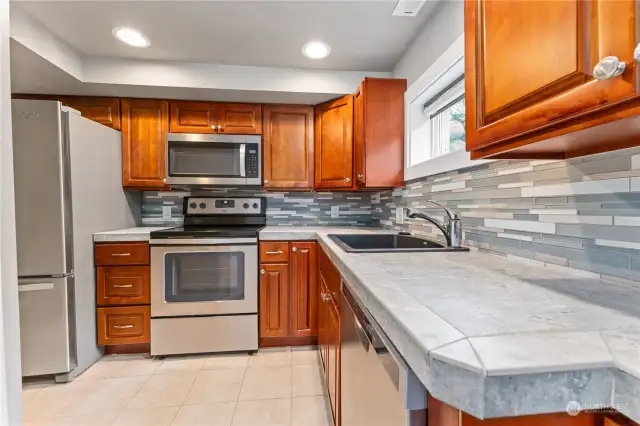 Tiled counter tops, stainless steel appliances, tile floors for easy cleaning and beautiful cabinets with plenty of storage.