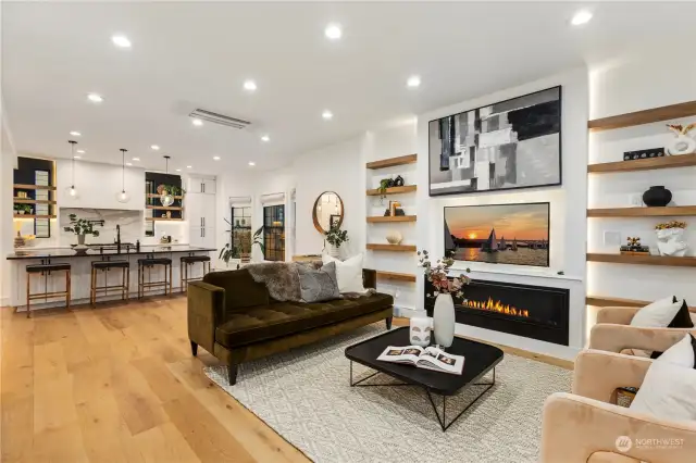 Main floor living room looking over to the kitchen. Engineered hardwood floors with air-conditioning through out. Google Home Alexa installed to control lighting and a variety of different commands.