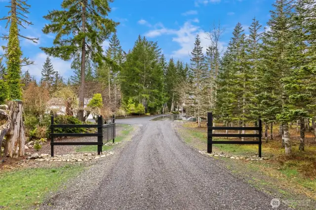 A stately gate leads to the industrial shop to the left and main house straight ahead.