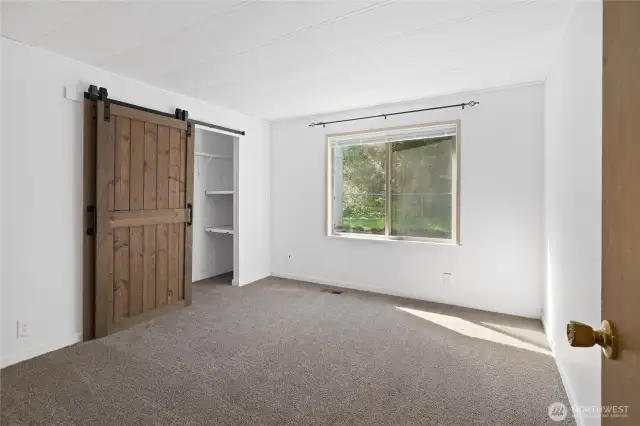2nd bedroom lots of light in here and custom barnwood door for extra large closet.