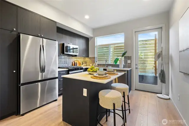 The chef-inspired kitchen features a large island with seating, stainless steel appliances, and designer cabinetry.