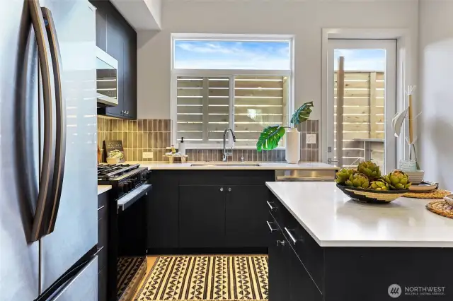 Bright and stylish, this kitchen combines clean lines with warmth from the natural light and backsplash.
