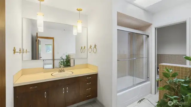Bathroom features glass enclosure for the shower & tub, separate water closet, & a skylight.
