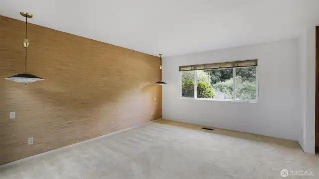 Another view of the primary bedroom showcasing stylish light fixtures and feature wall.