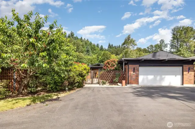 Exceptional street appeal with beautiful landscaping, fruit trees & garden wall with gate that opens to the aggregate courtyard.