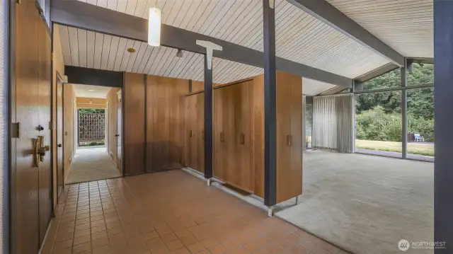 Double door entry to rustic floor tiling and practical storage.