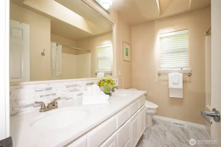 Upstairs Hall Bath with Double Sinks & Stone Counters & Tub/Shower Enclosure & Tile Floors.