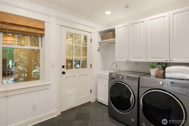 Well placed, functional yet stylish mudroom with laundry has dog run right outside the side door for convenience.