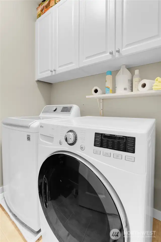 The laundry room is centrally located between the bedrooms and has cabinets above for added storage.  There is also a linen closet in the hallway for additional storage.