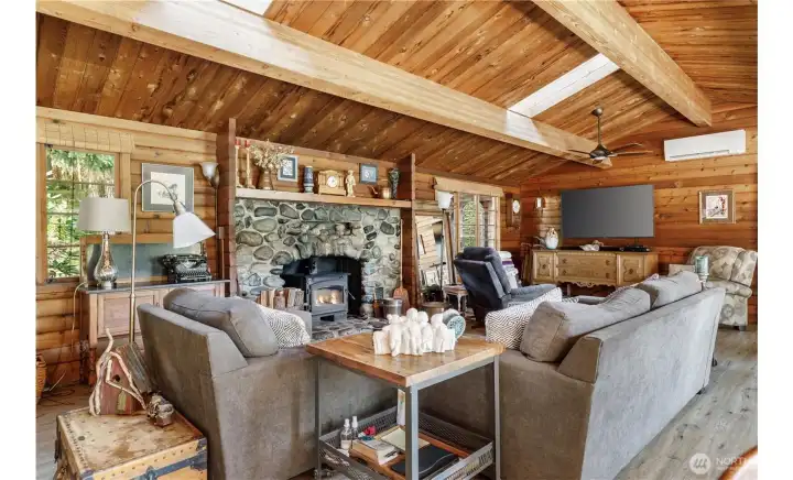 You'll admire this custom stone fireplace with real stones (not concrete stones!).  Wood stove provides ample heat, although there also is a mini split here. Go outside to take a look at the full feature river rock fireplace, it is wonderfully beautiful.