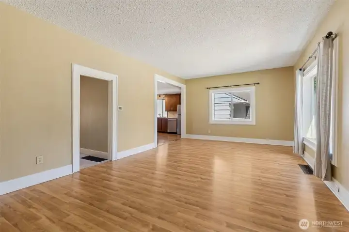 Unit A: Here is the living room with hallway to laundry room and full bath and den on the left and then the kitchen on the right.