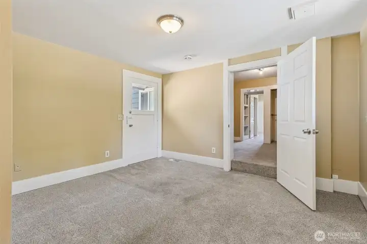The back bedroom in Unit A is ready to become your personal sanctuary. With its own 3/4 bathroom and an exterior door that leads straight to the deck, it has everything you need. Accessed through the den, it features oatmeal-toned carpeting, warm paint, and fresh white trim. The layout is anything but ordinary, offering options to suit whatever your lifestyle demands, whether that’s a primary bedroom or something totally different.