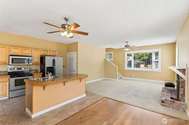 Unit B’s kitchen is a perfect blend of style and function. The tile flooring in tan stone tones sets the mood, while the kitchen island with a sink and dishwasher makes prep and cleanup a breeze. Stainless steel appliances, warm wood-tone shaker cabinetry, and a glass-topped electric stove add both charm and practicality. No more worrying about gas being left on, and the French door fridge with water and ice dispenser is ready for all your chilled beverages.