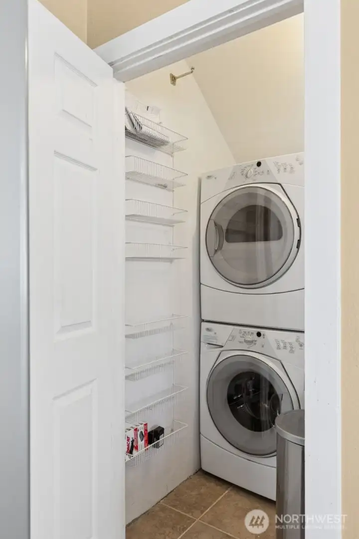 In Unit B, convenience is key with a combo pantry and laundry room right next to the kitchen. The stacked front-loading washer and dryer take up minimal space while still getting the job done. The durable tile floor matches the kitchen, so it’s stylish and practical. It’s the kind of setup that makes laundry a breeze and doesn’t take away from the flow of the home.