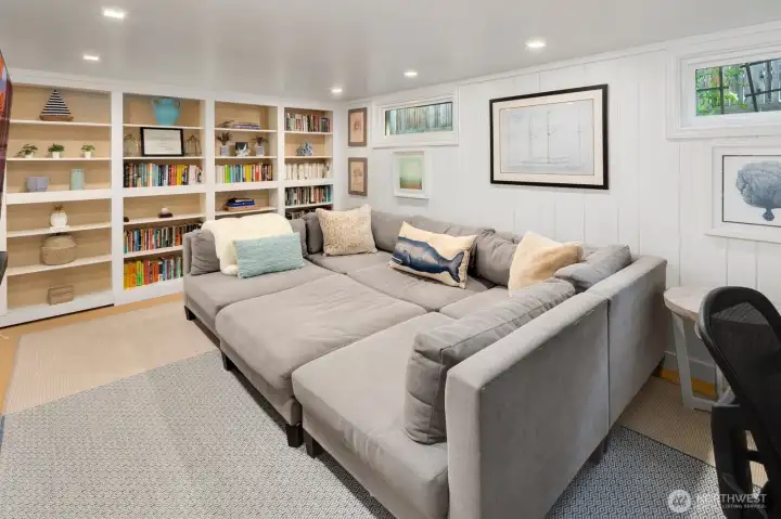 The lower level offers fantastic flexibility with a cozy media room (or optional fourth bedroom), laundry area, abundant storage, and a hidden speakeasy-style room tucked behind custom built-ins—a perfect space for entertaining or relaxing in style.