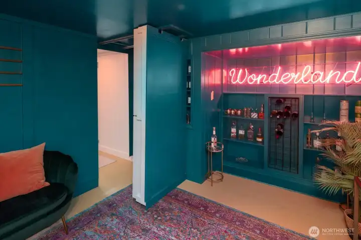 Hidden speakeasy-style room tucked behind custom built-ins—a perfect space for entertaining or relaxing in style.