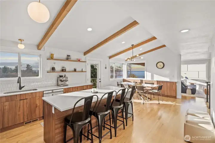Enter to a gorgeous modern kitchen with open shelving, huge island and views!