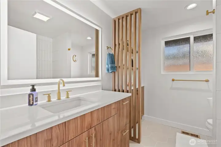 Full bath on the main floor is designed to flow with the cabinetry and feel of the main floor finishes