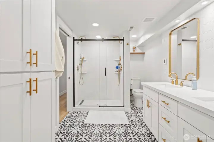 Another spa like bathroom for the lower level This is access from the hallway and the second primary walk in closet for privacy!  Whimsical floors, dual vanity and a double head shower!