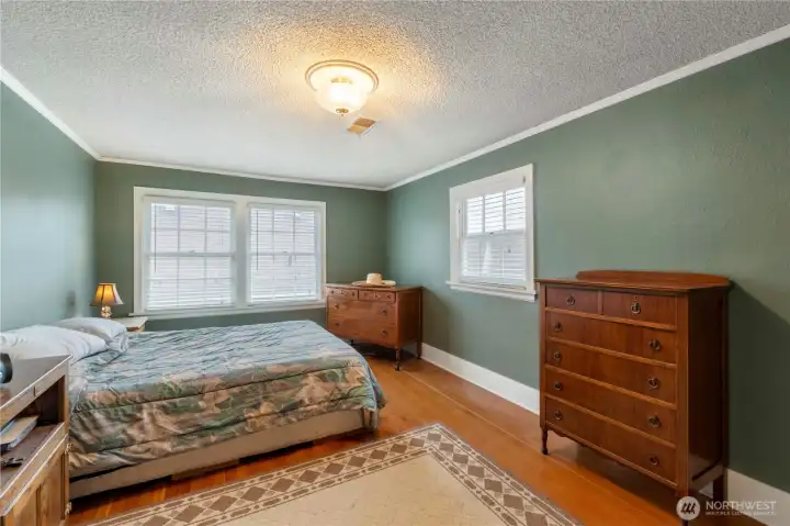 Large bedroom wood floors crown molding and walk in closet