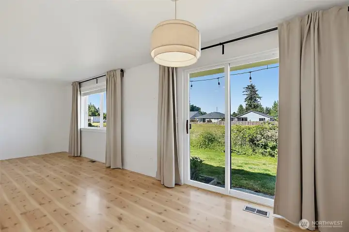 Kitchen nook area with updated lighting with sliding door out to backyard patio.
