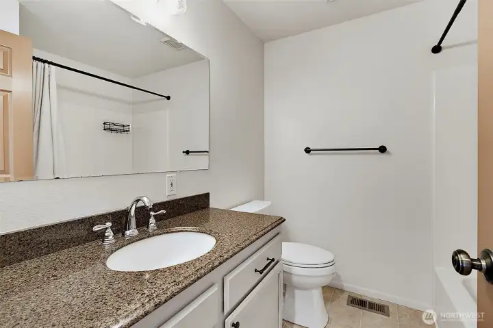 Full bathroom has a nice large countertop with storage under sink + linen closet behind the door.