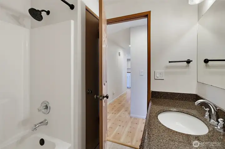 Full Bathroom with granite sink & linen closet behind the door.
