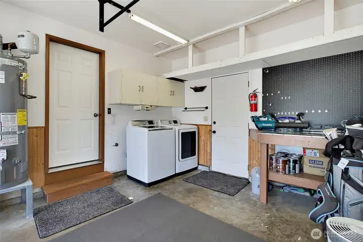 Laundry located in garage just off kitchen area. Garage also houses the furnace, hot water tank, extra storage + tool bench with nice peg board to keep you tools organized.