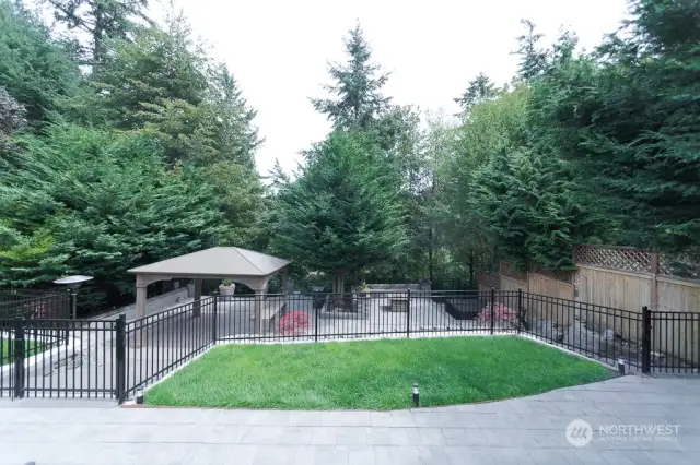 part of the large back yard and railing seperating the patio and yard