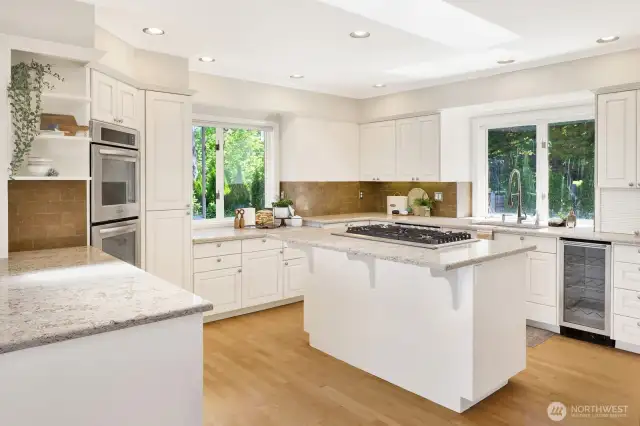 Large kitchen features an island, gas stove, walk-in pantry, double ovens, new refrigerator, and wine fridge.