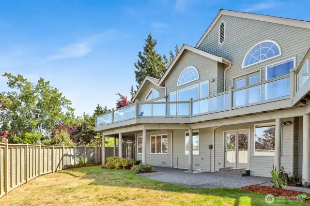 Note the large fenced yard, patio, and wrap-around upper deck