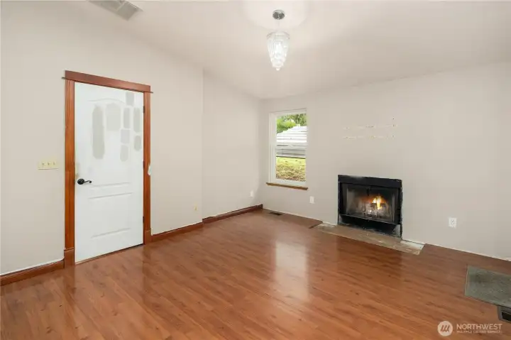 Bright and inviting! This living room features a teardrop chandelier and a true wood-burning fireplace for warmth and charm.