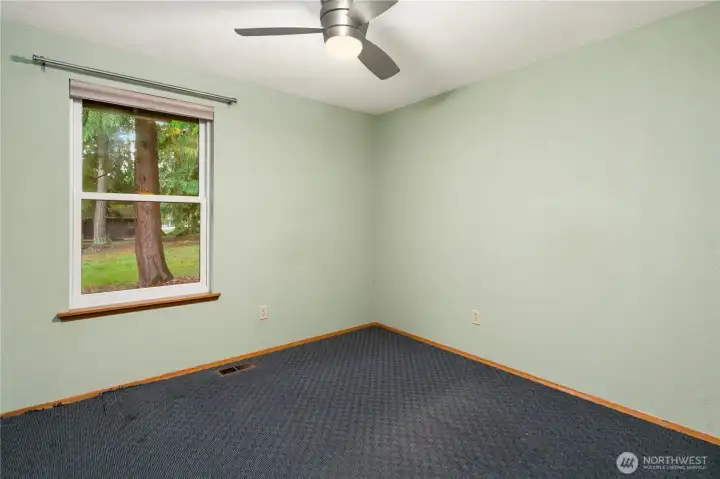 Morning light filters into this bedroom which features a ceiling fan, wall-length double sliding closets doors ,wall-to-wall carpet and a lovely view.