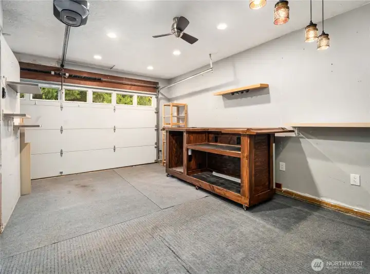 A versatile garage and workspace designed for work or play—recessed lighting, ceiling fan, shelving, and a custom rolling wood bar set the scene, while a convenient fridge/freezer and extra storage keep everything within reach. The garage door opens for easy access to outdoor entertaining.