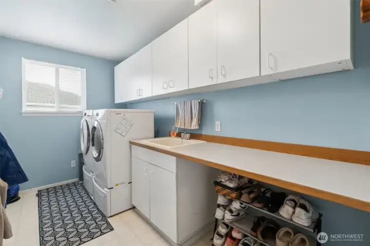 A laundry room with so much STORAGE - this is so helpful when managing and folding laundry.