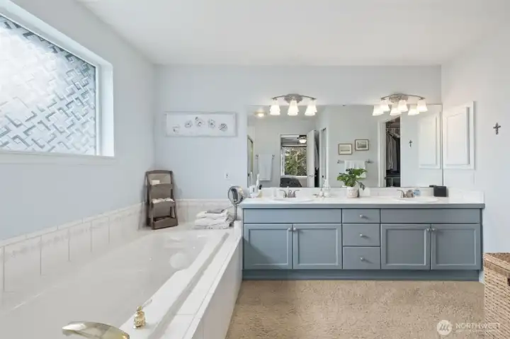 Primary Bathroom with luxurious soaking tub, updated lighting and vanity with double-sinks and loads of storage.