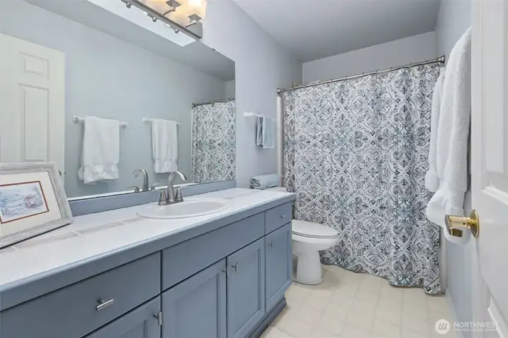 Hall bathroom with ample storage and tub/shower combination.