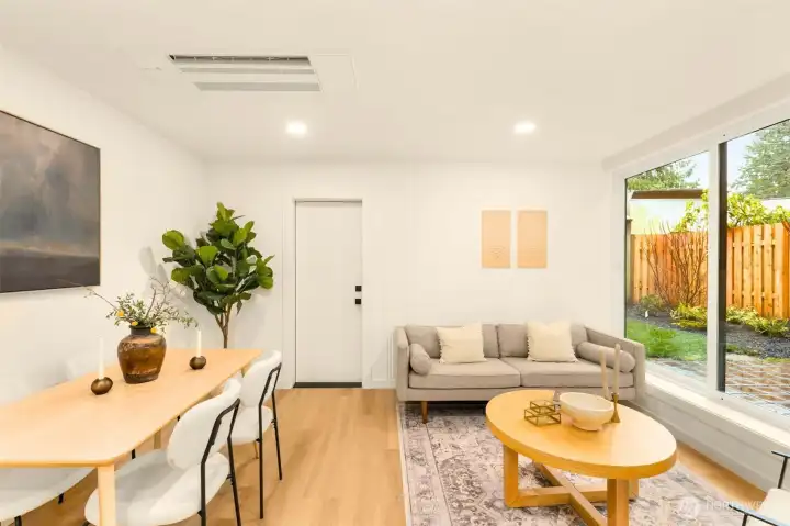 Moving over, the bright, naturally lit living and dining space echoes the same level of detail and care through its walls, with stunning wall molding, tall baseboards, and a built into mini-split in the ceiling giving the living space that much more room to breathe